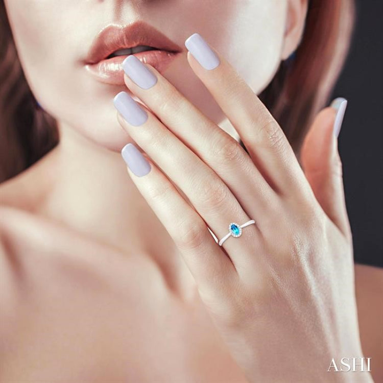 5x3 MM Oval Shape Blue Topaz and 1/20 Ctw Round Cut Diamond Halo Semi-Precious Ring in 10K White Gold